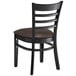 A Lancaster Table & Seating black wood ladder back chair with dark brown vinyl seat.