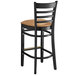 A Lancaster Table & Seating black wood bar stool with light brown vinyl seat.