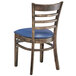 A Lancaster Table & Seating wooden ladder back chair with navy vinyl seat and back.