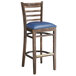 A Lancaster Table & Seating wood bar stool with a navy vinyl seat.