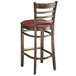 A Lancaster Table & Seating wooden bar stool with a burgundy vinyl seat.