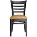 A black Lancaster Table & Seating wood ladder back chair with light brown vinyl seat.