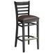 A Lancaster Table & Seating black wood bar stool with dark brown vinyl seat cushion.