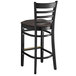 A Lancaster Table & Seating black wood ladder back bar stool with a dark brown cushion.