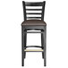 A Lancaster Table & Seating black wood ladder back bar stool with dark brown vinyl seat.