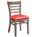 A Lancaster Table & Seating wood ladder back chair with a red vinyl seat