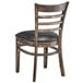 A Lancaster Table & Seating wooden ladder back chair with black vinyl seat detached.