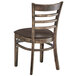 A Lancaster Table & Seating wooden ladder back chair with dark brown vinyl seat.