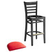 A black wood bar stool with a red vinyl seat and ladder back.