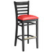 A black Lancaster Table & Seating wood bar stool with a red vinyl seat.