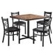 A Lancaster Table & Seating butcher block table with 4 black chairs.