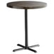 A Lancaster Table & Seating round bar height table with a wooden top and cast iron base plate.