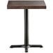 A Lancaster Table & Seating square wood table with espresso finish and cast iron base.