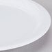 A close up of a white Carlisle Dallas Ware melamine plate with a white rim.