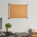 A Dynamic by 360 Office Furniture cork board with aluminum frame mounted on a wall.