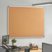 A Dynamic by 360 Office Furniture cork board with aluminum frame mounted on a wall.