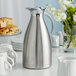 An Acopa Lustrous stainless steel thermal carafe on a table.