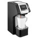 A black and white Hamilton Beach coffee maker with a white cup on top.