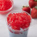 A bowl of strawberry ice cream topped with red jelly.