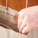 A hand opening a Sabert tamper-evident brown paper bag.