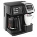 A black Hamilton Beach coffee maker with a white cup on top.