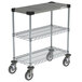 A metal Metro Drive-Thru Order Staging Prep Cart with three wire shelves and wheels.