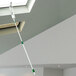 A man uses a Unger ProFlex duster on a pole to clean a ceiling.