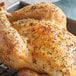 A whole chicken sprinkled with Regal Spanish thyme leaves on a baking sheet.
