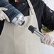 A person in a chef's uniform and gloves using an AvaMix heavy-duty blending shaft.