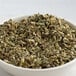 A bowl of Regal Mexican oregano leaves on a white table.