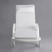 A white Lancaster Table & Seating resin chaise with a white cushion and pillow.