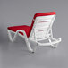 A white Lancaster Table & Seating chaise lounge with red cushion and pillow.