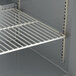 A white shelf with metal racks in a Beverage-Air undercounter freezer.