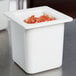 A white Carlisle Coldmaster food pan with diced tomatoes inside.