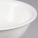 A close up of a CAC Garden State bone white porcelain nappie bowl with a wavy design.