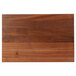 A John Boos walnut wood cutting board with hand grips on a wood surface.