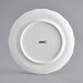 A white Acopa porcelain plate with scalloped edges and black text that reads "Condesa" in the center.