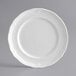 An Acopa Condesa white porcelain plate with a decorative scalloped edge.