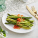 A white Acopa porcelain platter with asparagus and tomatoes.