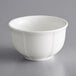 A white Acopa porcelain bouillon cup with a scalloped rim on a gray surface.
