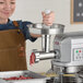 A woman using an Estella mixer hub meat grinder to grind meat.
