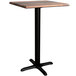 A Lancaster Table & Seating square counter height table with a textured farmhouse finish and black cross base.