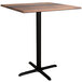 A Lancaster Table & Seating Excalibur square bar height table with a textured wooden top and black cross base.