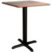 A Lancaster Table & Seating Excalibur square dining table with a textured wood top and black cross base.