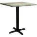A Lancaster Table & Seating square dining height table with a textured green surface and black cross base plate.