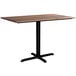 A Lancaster Table & Seating rectangular dining table with a wooden top and black cross base.