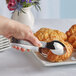 A hand using Acopa Industry stainless steel serving tongs to pick up a croissant.