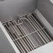 A metal rack inside a box with several metal utensils.