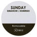 A roll of round white food labeling stickers with the words "Sunday" in black.