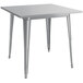 A silver square metal outdoor table with legs.